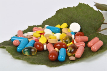 Colored pills on green leaf