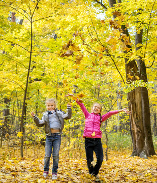 Happy Children Throwing Leaves Up