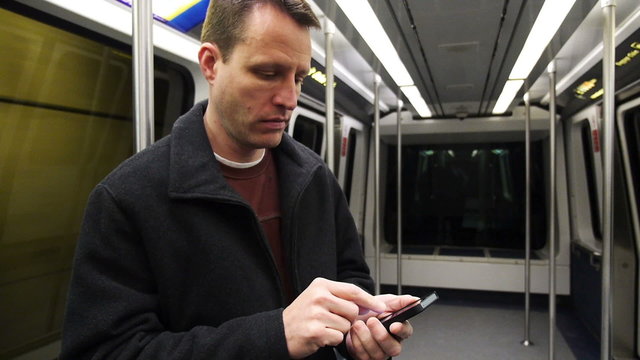 Man in Subway Uses Smartphone 3898