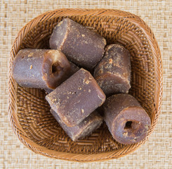 Coconut palm sap sugar or locally know as gula melaka over wicker background 