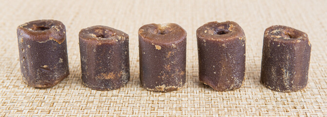 Coconut palm sap sugar or locally know as gula melaka over wicker background 