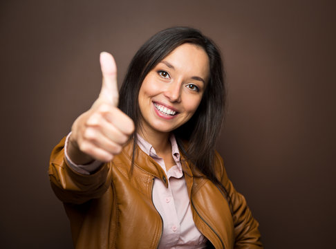 Woman giving thumbs up approval hand sign gesture smiling happy