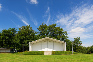 Open-air stage in a lush green park