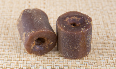 Coconut palm sap sugar or locally know as gula melaka over wicker background 