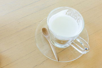 hot drink milk with spoon on wood table