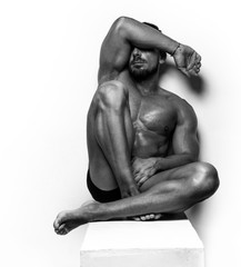 Muscular Man sitting on white