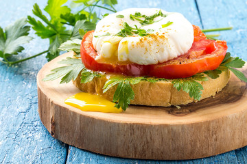 Toast with poached egg, tomatoes and parsley