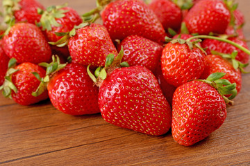Ripe strawberries heart shaped on wooden table, closeup