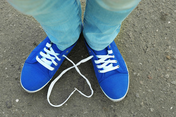 Female feet in gum shoes on asphalt background