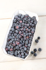 blaubeeren in pappschale auf Holztisch