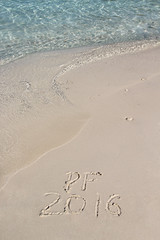 Handwriting inscription PF 2016 on the beach