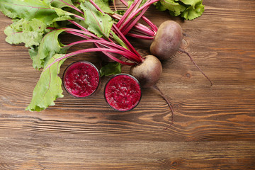 Glasses of beet juice with vegetables on table close up