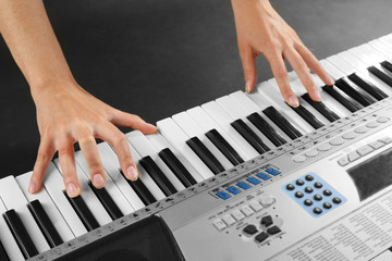 Woman playing synthesizer close up