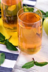 Glasses of apple juice with fruits and fresh mint on table close up