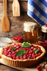 Tart with fresh raspberries, on wooden background