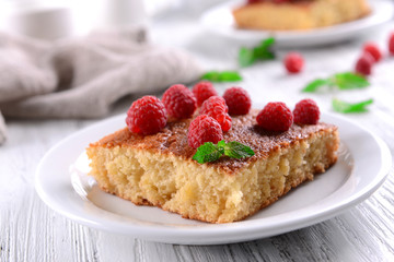 Fresh pie with raspberry in white plate on wooden table, closeup