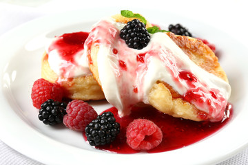 Fritters of cottage cheese with berries in plate, closeup