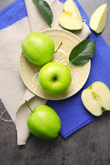 Green apples on wooden table with napkins, top view