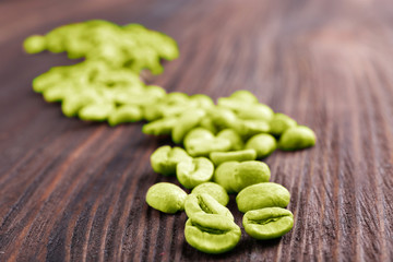 Green coffee beans on wooden background
