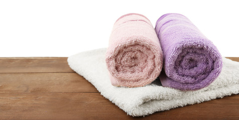 Obraz na płótnie Canvas Rolled bath towels on wooden table, closeup