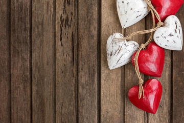 Red and white wooden hearts on old brown wooden background
