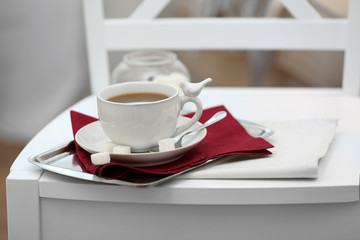 Cup of tea on chair in room