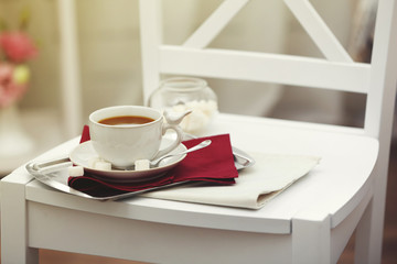 Cup of tea on chair in room