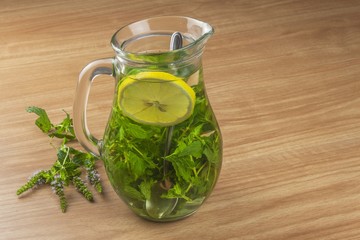 Fresh homemade mint tea. Tempting summer refreshment. Healthy, refreshing drink without sugar. Peppermint tea in a glass jar with lemon. Preparing tea.
