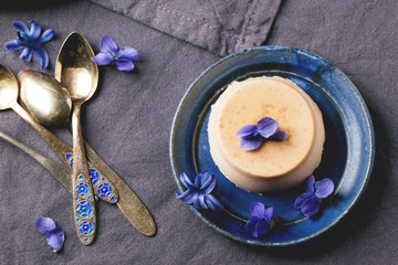 Caramel pannacotta with violet flowers