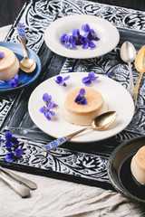 Caramel pannacotta with violet flowers