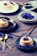 Caramel pannacotta with violet flowers