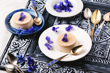 Caramel pannacotta with violet flowers