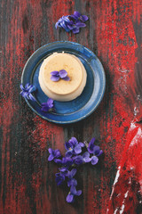 Caramel pannacotta with violet flowers