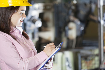 Mechanical engineer taking notes at metallurgy factory
