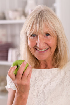 Frau Senior ist einen Apfel mit Freude