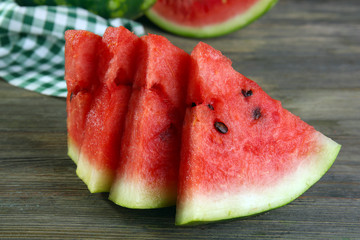Slices of ripe watermelon on wooden table close up