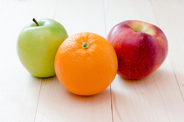 Apple and orange fruit on wooden background