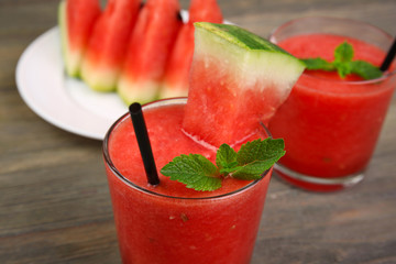 Glasses of watermelon juice on wooden table, closeup