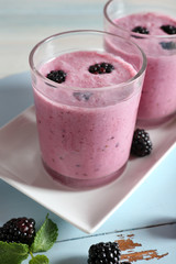 Delicious berry smoothie with blackberries on wooden table close up