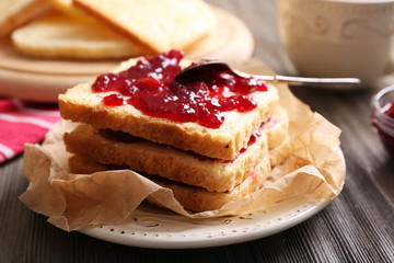 Bread with butter and homemade jam on crumpled parchment, closeup