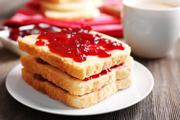 Bread with butter and homemade jam on wooden table, closeup