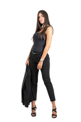 Serious young business woman holding her jacket posing at camera.