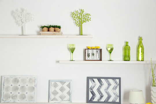 Different home objects and decoration on shelves on white wall background