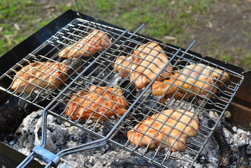 Barbecue chicken over an open fire in  summer