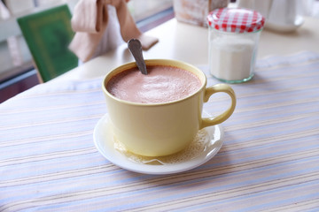 Mug of hot cocoa on table in cafe