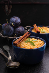 crumble with plums and cinnamon on a black background