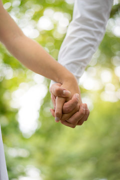 A young couple holding hands in the park, London.