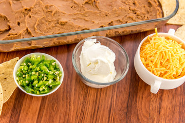 preparation of bean dip with jalapenos, sour cream and cheddar c
