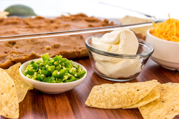 preparation of bean dip with jalapenos, sour cream and cheddar c
