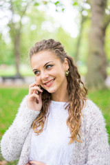  Young woman using mobile phone & message in summer park